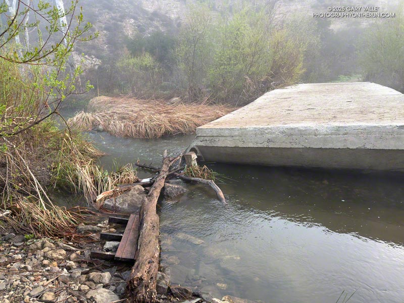 When the seasonal bridge has been removed for the rainy season, trail users create a makeshift bridge across Malibu Creek. March 16, 2025.