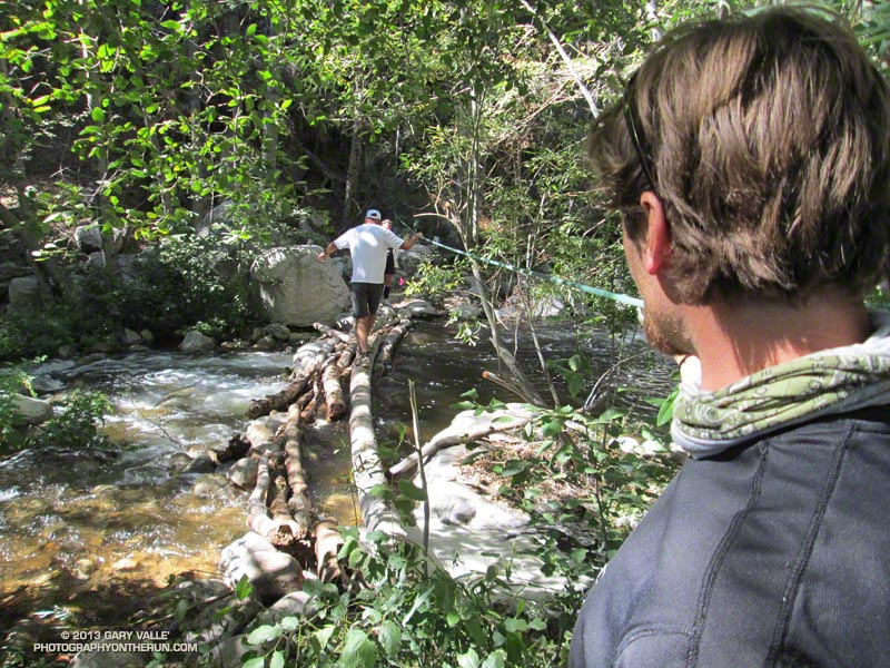 From the 2013 50M. Eric Bulrice steadies the rope on the crossing over Bear Creek as a pacer goes back to grab a camera. This crossing is a crucial water stop before the approximately 7 mile, 3000' climb to the Champion Lodgepole Aid Station. (Photo @ mile 26.6/79.5)