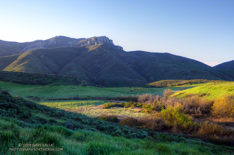 The first rays of sunlight highlight a frosty Satwiwa meadow and cold crags on Boney Mountain.
